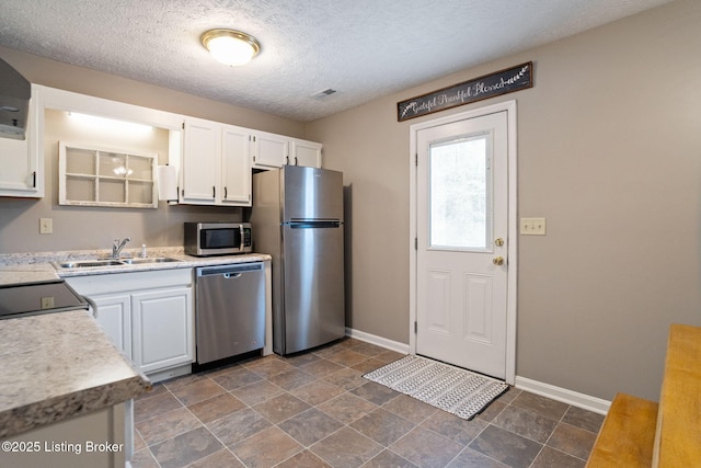 kitchen featuring baseboards, a sink, white cabinets, and stainless steel appliances