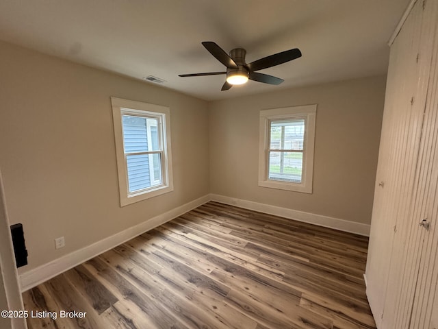 unfurnished bedroom featuring visible vents, baseboards, a ceiling fan, and wood finished floors