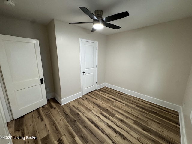 unfurnished bedroom with wood finished floors, baseboards, and a ceiling fan