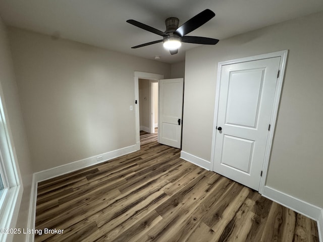 unfurnished bedroom with baseboards, a ceiling fan, and wood finished floors