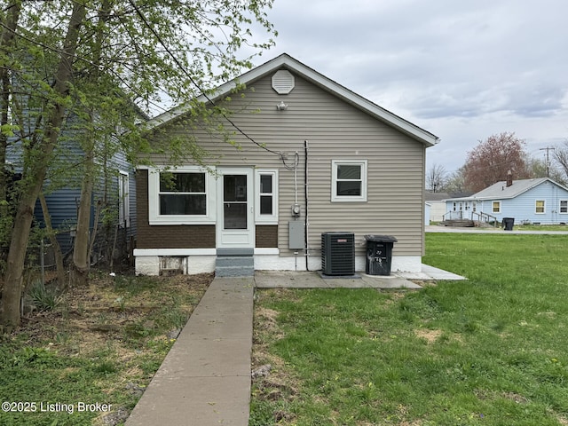 view of front facade featuring a front yard, brick siding, and cooling unit