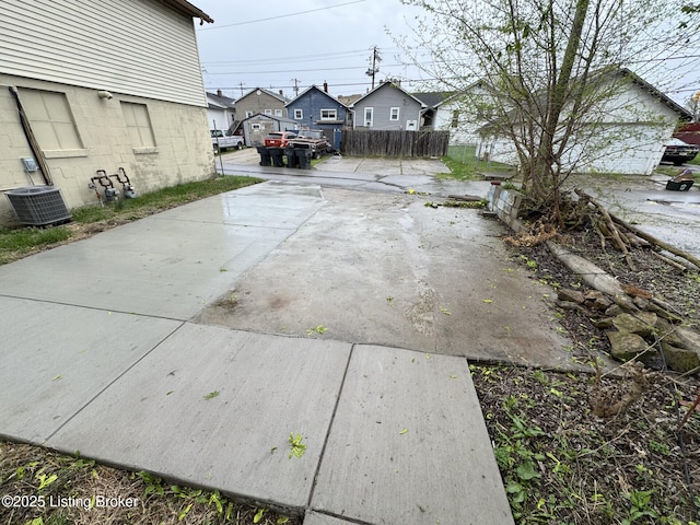view of yard with fence, a residential view, and central AC