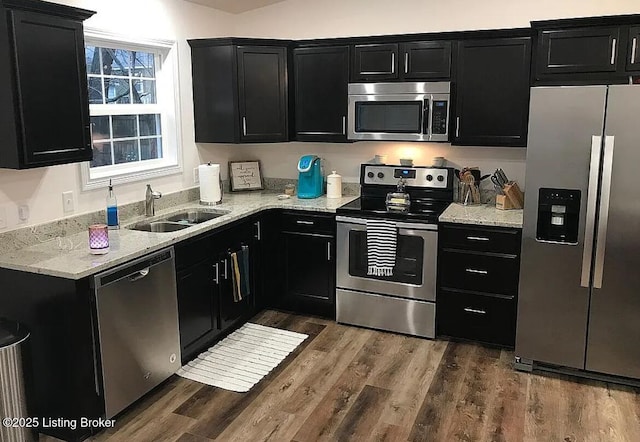 kitchen with a sink, appliances with stainless steel finishes, and dark cabinets