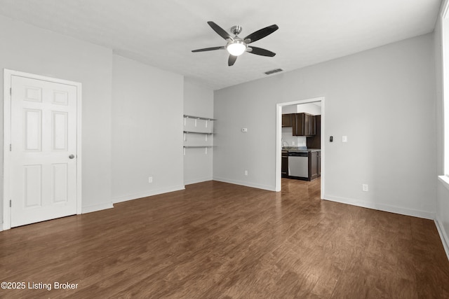 interior space with a ceiling fan, baseboards, dark wood finished floors, and visible vents