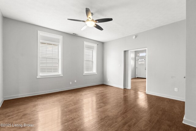 empty room featuring visible vents, baseboards, a ceiling fan, and wood finished floors