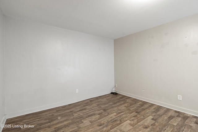 spare room featuring wood finished floors and baseboards