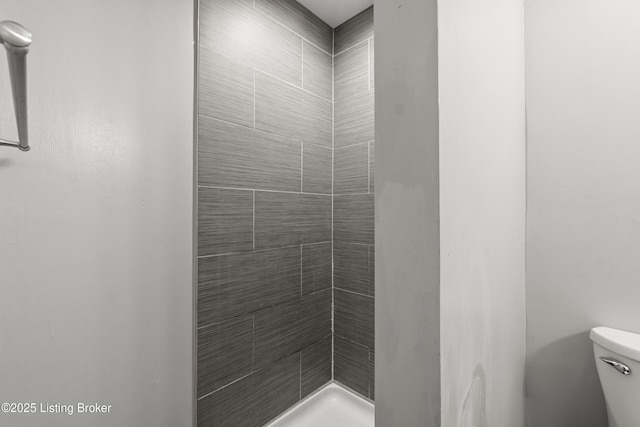 bathroom featuring toilet and a stall shower