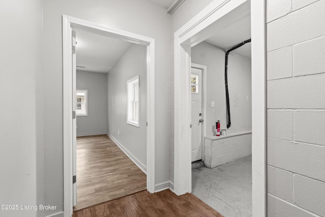 corridor with dark wood-type flooring and baseboards