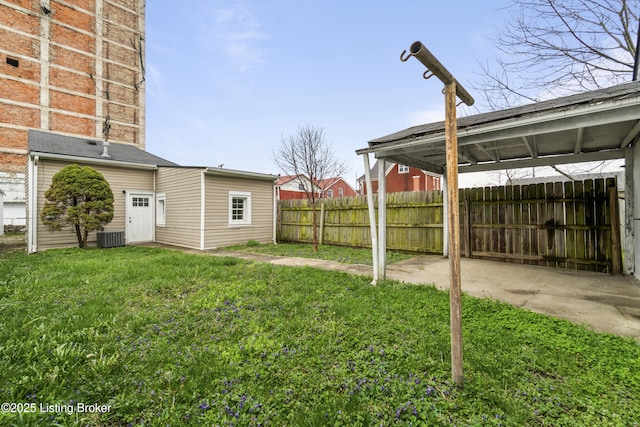view of yard featuring central air condition unit and fence