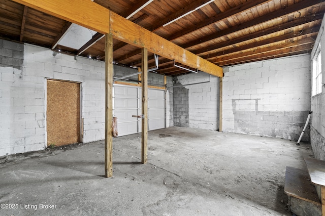 basement featuring a garage and concrete block wall