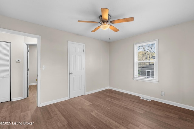 unfurnished bedroom featuring wood finished floors, visible vents, and baseboards