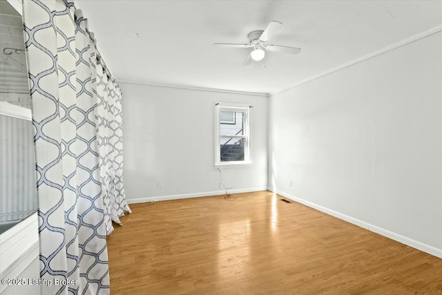 spare room with visible vents, ceiling fan, light wood-style floors, and baseboards