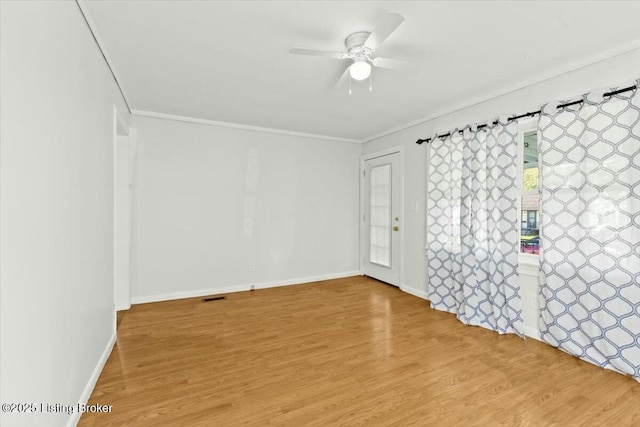 unfurnished room with visible vents, baseboards, a ceiling fan, crown molding, and wood finished floors