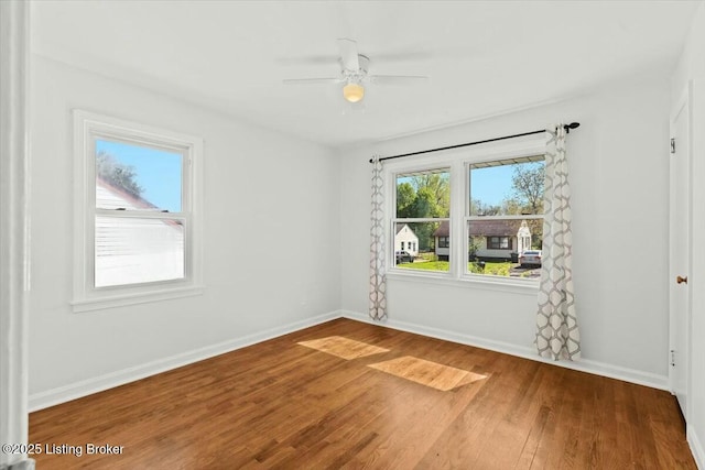 unfurnished room with ceiling fan, baseboards, and wood finished floors