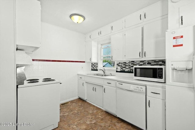 kitchen with white appliances, light countertops, white cabinets, visible vents, and a sink