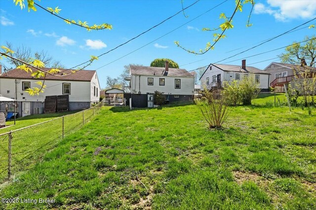 view of yard featuring fence, cooling unit, and a residential view
