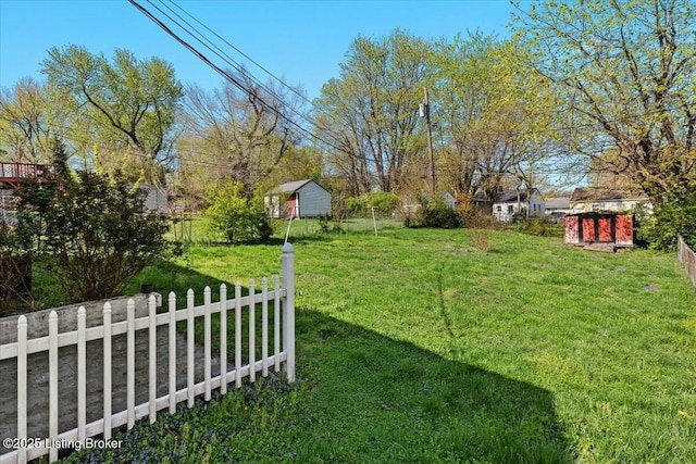 view of yard with a shed, a fenced backyard, and an outdoor structure