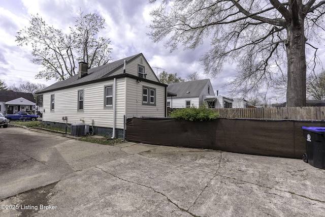 1125 W Whitney Ave, Louisville, KY 40215 - view of side of home with fence, cooling unit, and a chimney