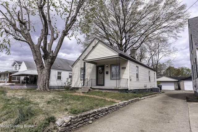 1125 W Whitney Ave, Louisville, KY 40215 - shotgun-style home featuring an outbuilding, a garage, central AC unit, and covered porch