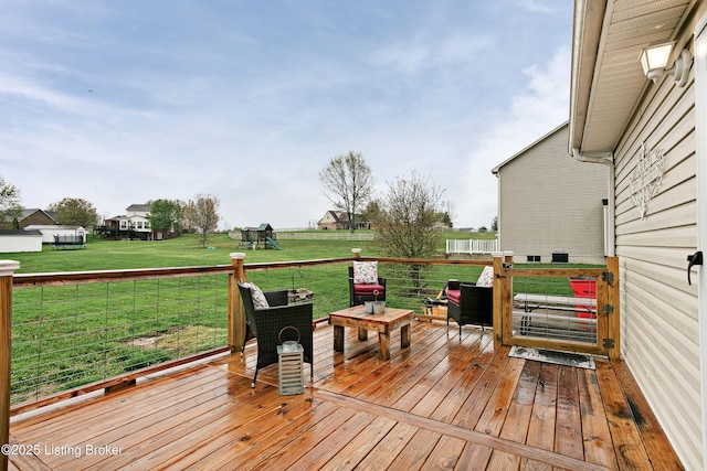 wooden deck with a yard and a playground