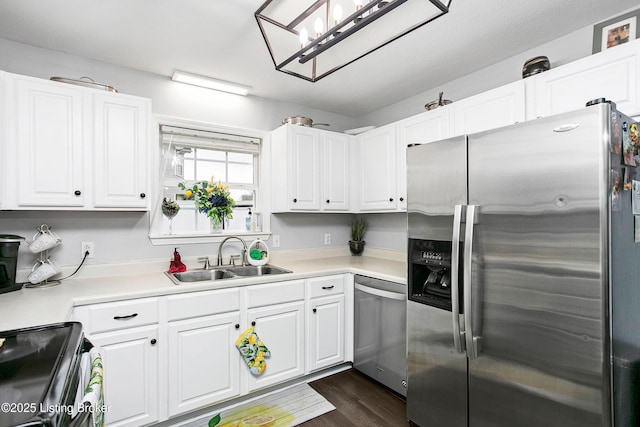 kitchen featuring white cabinets, a sink, dark wood-style flooring, light countertops, and stainless steel appliances
