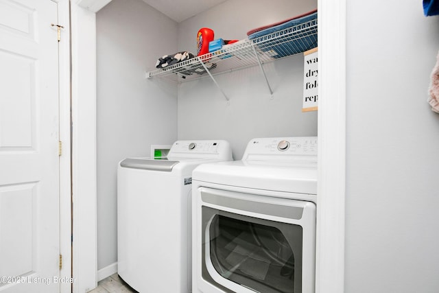 washroom featuring light wood finished floors, laundry area, and washing machine and clothes dryer