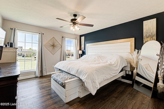 bedroom with baseboards, multiple windows, and dark wood-type flooring