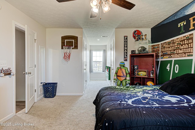 carpeted bedroom with a textured ceiling, a ceiling fan, baseboards, and visible vents