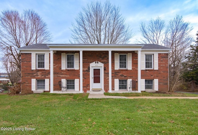 bi-level home featuring a front lawn and brick siding