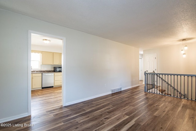 unfurnished room with dark wood-type flooring, baseboards, and visible vents