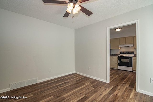 spare room with dark wood-type flooring, visible vents, baseboards, and a ceiling fan