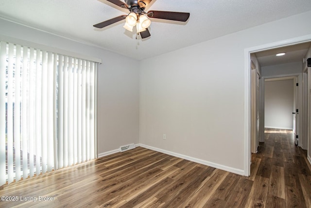 empty room featuring visible vents, ceiling fan, wood finished floors, and baseboards