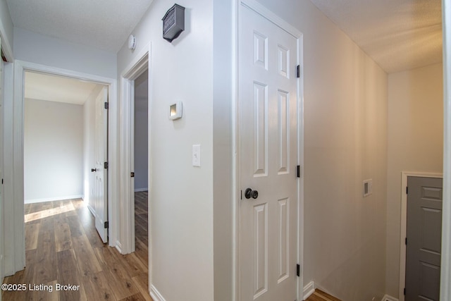 hall featuring baseboards and wood finished floors