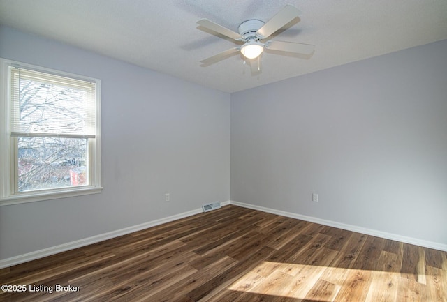 unfurnished room with visible vents, baseboards, ceiling fan, and wood finished floors