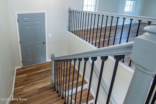 staircase with baseboards and wood finished floors