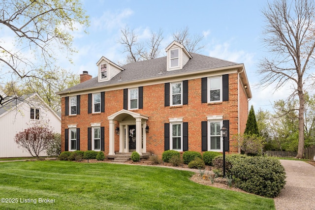 view of front of home featuring fence, a front lawn, and brick siding