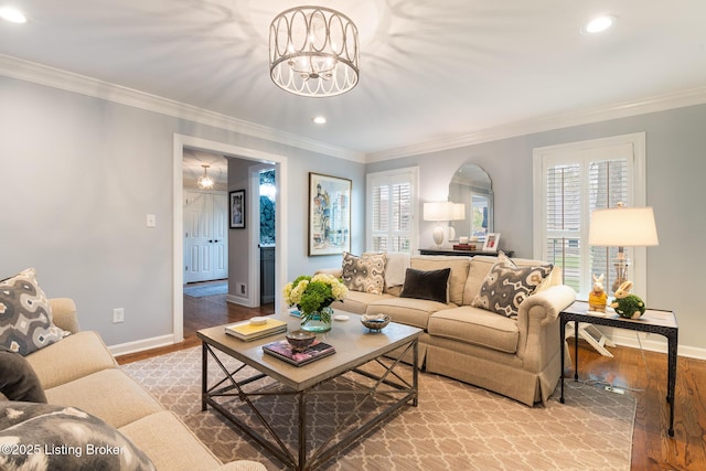living room with a notable chandelier, baseboards, recessed lighting, crown molding, and wood finished floors