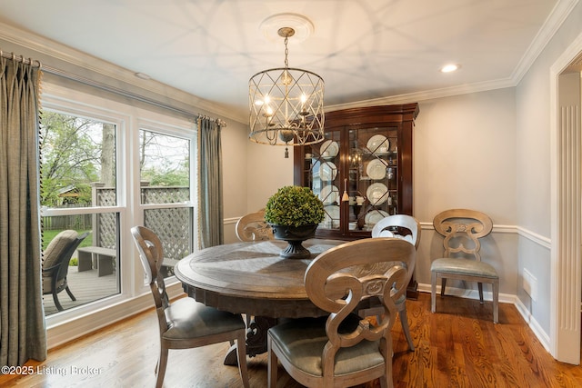 dining area featuring baseboards, an inviting chandelier, ornamental molding, recessed lighting, and wood finished floors