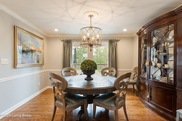 dining area with ornamental molding, light wood finished floors, an inviting chandelier, and recessed lighting