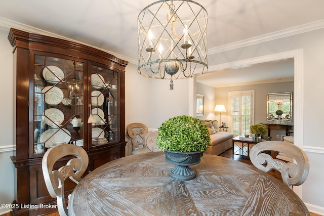 dining space with crown molding and a chandelier