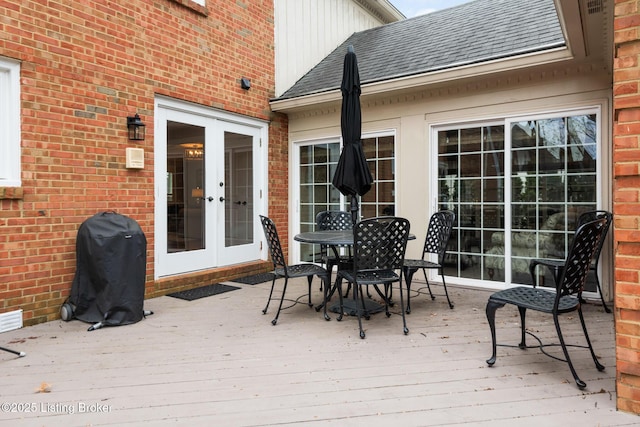 wooden deck featuring a grill, french doors, and outdoor dining area