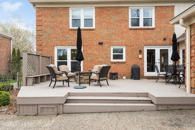 back of property with brick siding, french doors, and a wooden deck