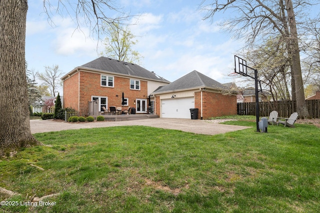 rear view of property featuring a yard, fence, brick siding, an attached garage, and driveway