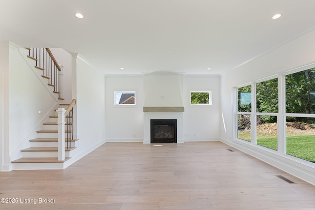 3238 Catalpa Farms Dr, Fisherville, KY 40023 - unfurnished living room featuring light wood-style floors, ornamental molding, stairway, a glass covered fireplace, and recessed lighting