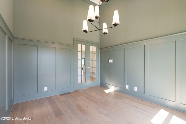 3238 Catalpa Farms Dr, Fisherville, KY 40023 - unfurnished room with a decorative wall, a chandelier, french doors, light wood-style flooring, and a towering ceiling