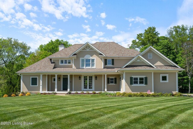 view of front of home featuring a porch, a chimney, and a front lawn