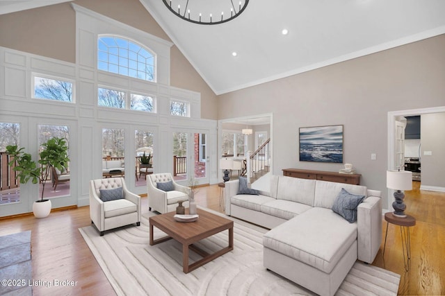 living area featuring high vaulted ceiling, stairway, recessed lighting, light wood finished floors, and a notable chandelier