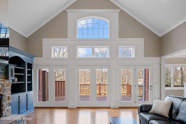 living room featuring plenty of natural light, wood finished floors, and high vaulted ceiling