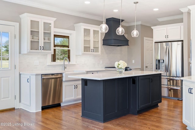 kitchen featuring custom range hood, light countertops, white cabinets, and stainless steel appliances