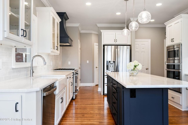 kitchen with white cabinets, appliances with stainless steel finishes, premium range hood, and tasteful backsplash